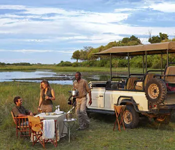 A table set for two beside a safari vehicle