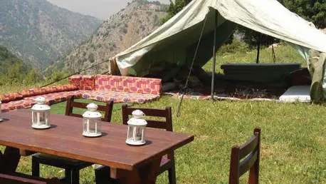 A camp table beside a canvas tent